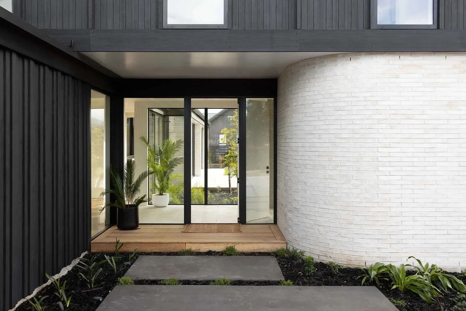Sheltered entrance with glazing, brick and timber