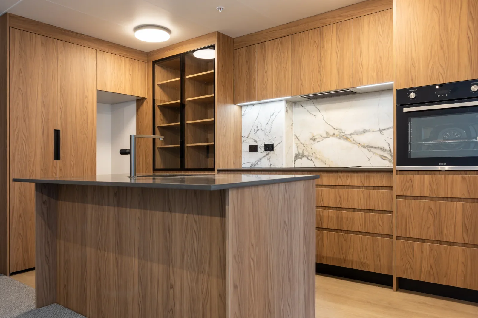Custom walnut kitchen cabinetry and stone splashback